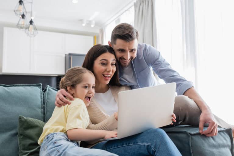 Family viewing laptop together, exploring mortgage options and financial advice.